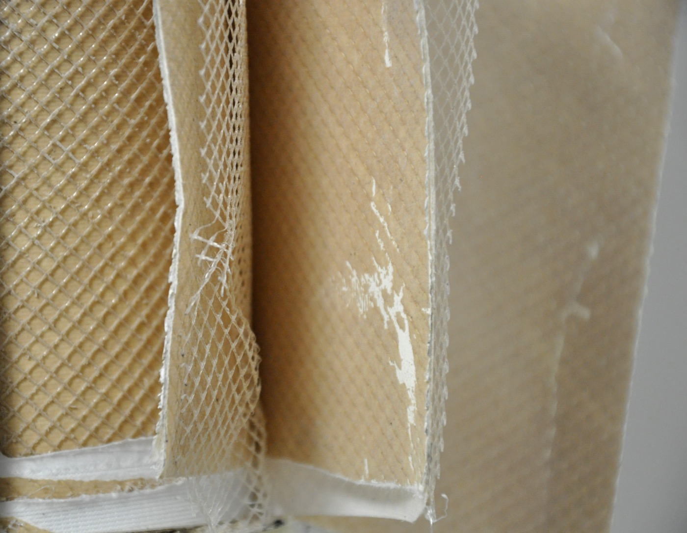 Capas desplegadas de una membrana con malla blanca y depósitos de color marrón